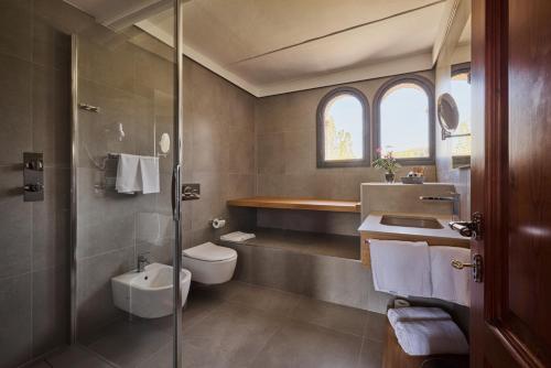 a bathroom with a toilet and a sink and a shower at UNA Hotels Monterufoli Wine Country in Monteverdi Marittimo