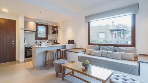 a living room with a couch and a kitchen at La Madrina Apart Hotel in Tafí del Valle