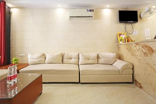 a living room with a couch and a tv at HOTEL ICONIC At Delhi International Airport in New Delhi