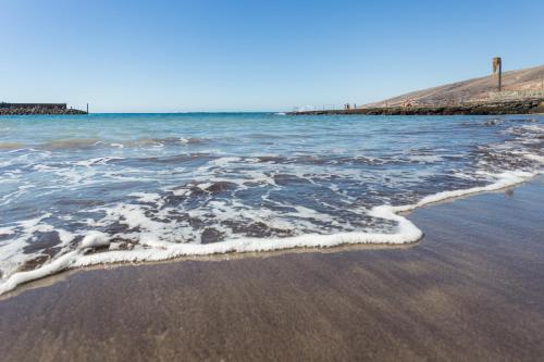 a beach with the water washing up on the shore at Home2Book Comfy Apt Puertito de Güímar, Pool in Puertito de Güímar