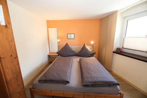 1 dormitorio con 1 cama con 2 almohadas en Gästehaus Villa Wernz, en Albisheim