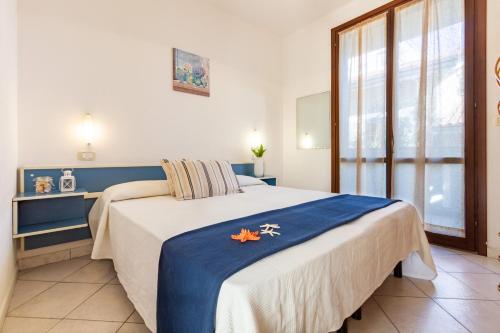 - une chambre avec un grand lit et une couverture bleue dans l'établissement Appartamento Dalila Bilo 1P - MyHo Casa, à Tortoreto Lido