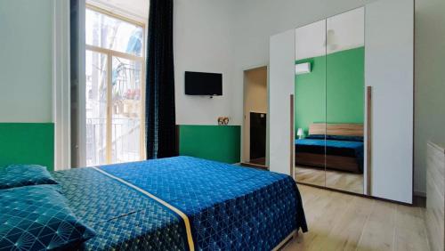 a bedroom with a blue bed and a mirror at DUHOME apartment in the heart of Catania in Catania