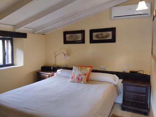 a bedroom with a white bed with a pillow on it at Finca El Zurrador in Fuenteheridos