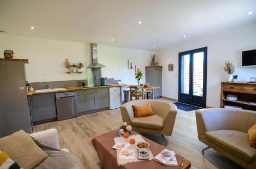 un salon avec un canapé et une table et une cuisine dans l'établissement Le Quai Huppé, voie 1, à Noyelles-sur-Mer