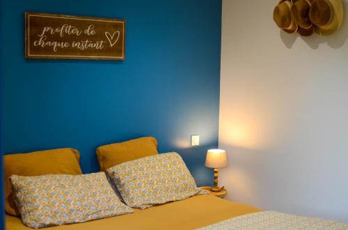 une chambre avec un lit avec un mur bleu dans l'établissement Le Quai Huppé, voie 1, à Noyelles-sur-Mer