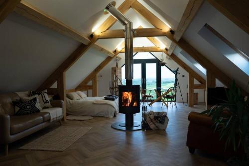 ein Wohnzimmer mit einem Kamin im Dachgeschoss in der Unterkunft Bedport Loft in Burrington