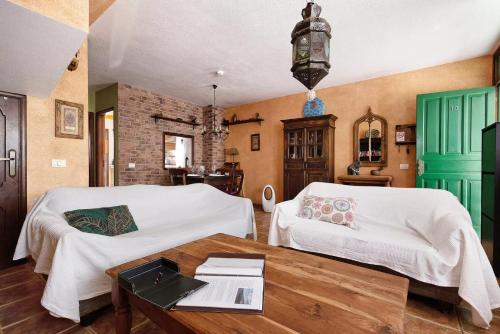 a bedroom with two beds and a wooden table at Casa Manus in Alcalá