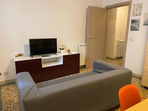 a living room with a couch and a flat screen tv at Ostello Europa in San Vito al Tagliamento