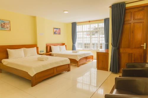 a hotel room with two beds and a window at Thùy Trang Hotel in Vung Tau