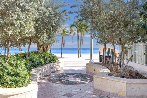 a walkway with trees and the beach in the background at Hollywood Apartments Host by BeeNomad in Hollywood