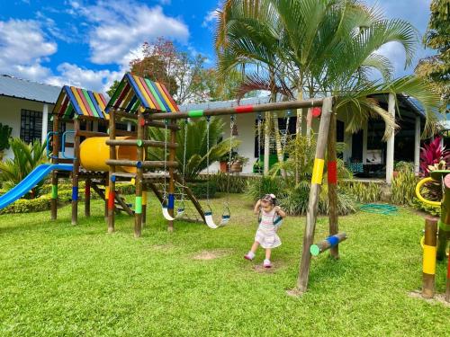 a little girl playing in a playground at Finca Santa Clara, Rivera-Huila in Rivera