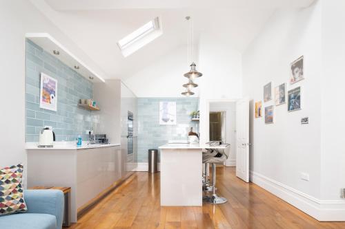 een keuken en een woonkamer met een blauwe tegelmuur bij Spacious Sillwood Street - Brighton in Brighton & Hove