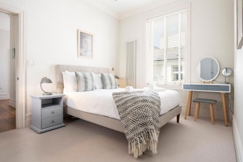 Habitación blanca con cama y espejo en Spacious Sillwood Street - Brighton, en Brighton & Hove