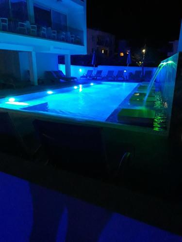 a swimming pool at night with blue lights at Sunny Blue Hotel in Ayia Napa