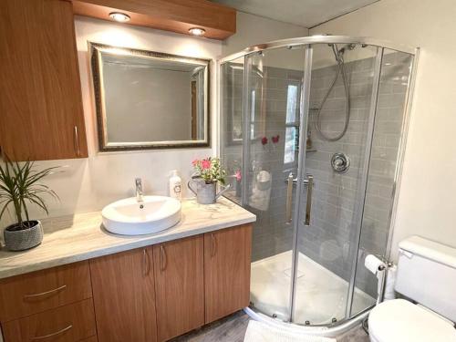 La salle de bains est pourvue d'une douche et d'un lavabo. dans l'établissement Chalet Falaise by Chalets NABU, à Saint-Alexis-des-Monts