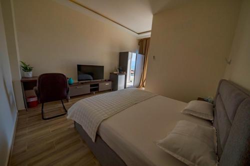 een slaapkamer met een bed, een bureau en een koelkast bij AQABA PRO DIVERS in Aqaba