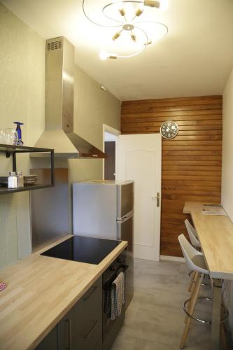 Il comprend une cuisine équipée d'un réfrigérateur et d'une table avec des chaises. dans l'établissement Le Refuge D'anne De Bretagne - à 2 minutes de la Gare Chateau de Blois - Le Refuge D'anne De Bretagne - 2 minutes from Chateau de Blois train station, à Blois