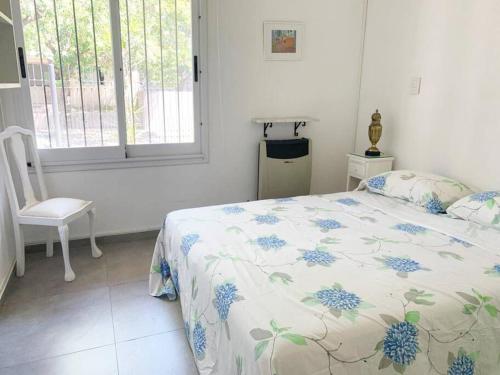 una camera con un letto e una sedia e una finestra di Casa con Jardín y Parrilla a Federación