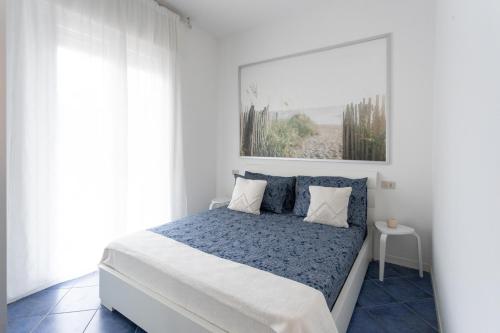 a white bedroom with a bed and a window at Casa Milano Marittima in centro tre locali con terrazzo in Milano Marittima