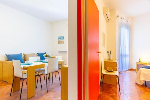 ein Esszimmer und ein Wohnzimmer mit einem Tisch und Stühlen in der Unterkunft Appartamento La Poesia Bilo - MyHo Casa in Tortoreto Lido