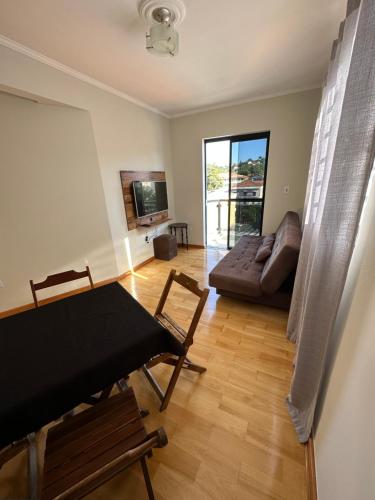 a living room with a table and a couch at Apartamento 32 no centro de Águas de São Pedro in Águas de São Pedro