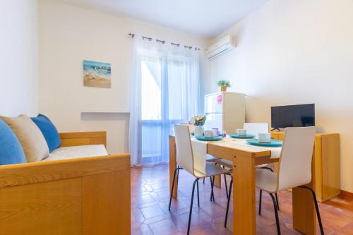 ein Wohnzimmer mit einem Tisch, Stühlen und einem Sofa in der Unterkunft Appartamento La Poesia Bilo - MyHo Casa in Tortoreto Lido