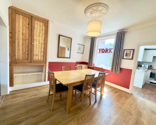 a kitchen and dining room with a wooden table and chairs at Great Town House - Central York in York