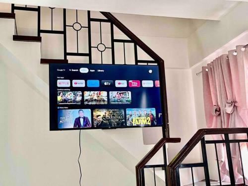 a flat screen tv hanging on a wall at Full Aircon Camella House w/ wifi Netflix hotwater in Butuan