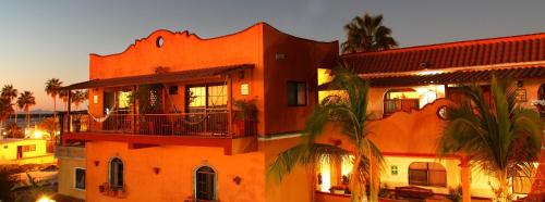 an orange building with a balcony and palm trees at Hotel Posada Luna Sol in La Paz
