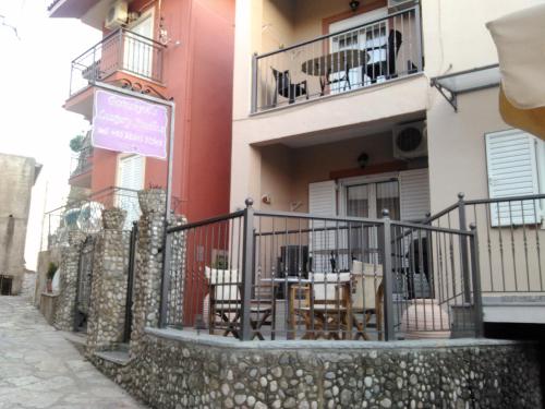 a building with tables and chairs on a balcony at Paraskevi's Luxury Studios in Parga