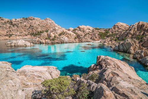 a body of water with rocks and blue water at Al Lungomare in Olbia