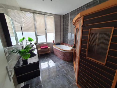 een badkamer met een bad, een wastafel en een toilet bij Loft, appartement in Morbier
