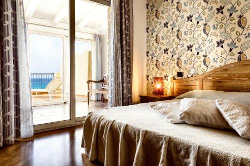 - une chambre avec un lit et une porte coulissante en verre dans l'établissement Stella Maris, à Villasimius
