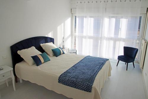 een slaapkamer met een bed, een stoel en een raam bij GINA Epernay Hyper-Centre 2-4 P in Épernay
