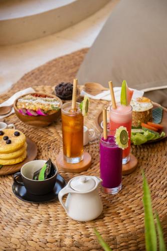a table with some drinks and food on it at Villa Tokay - The Luxury Resort in Gili Air