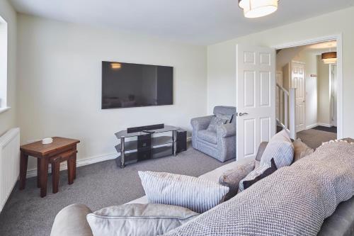 uma sala de estar com um sofá e uma televisão em Host & Stay - Town House em Seaham