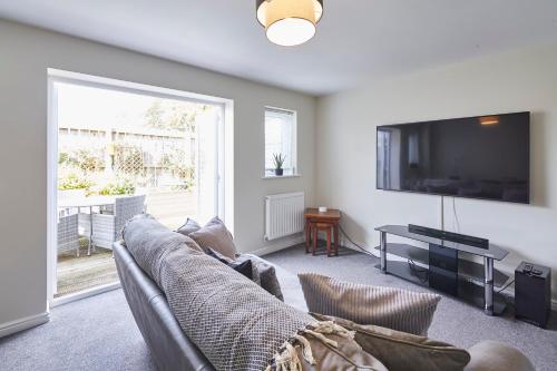uma sala de estar com um sofá e uma televisão de ecrã plano em Host & Stay - Town House em Seaham