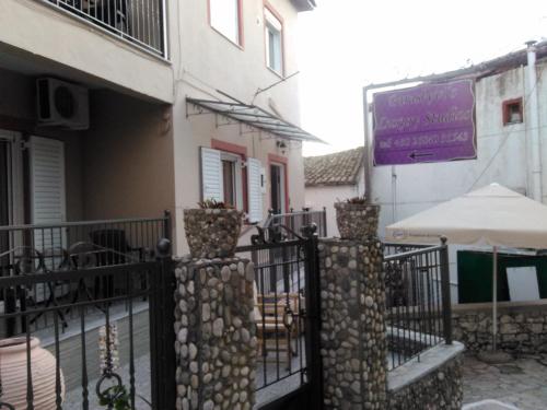 a balcony of a building with chairs and an umbrella at Paraskevi's Luxury Studios in Parga