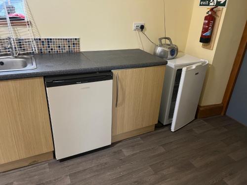 a kitchen with a sink and a dishwasher at Llanfyllin Workhouse - Y Dolydd in Llanfyllin