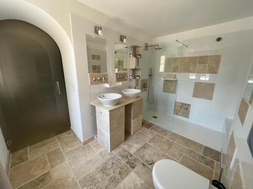 a bathroom with two sinks and a shower at Domaine de la Citerne in Nans-les-Pins