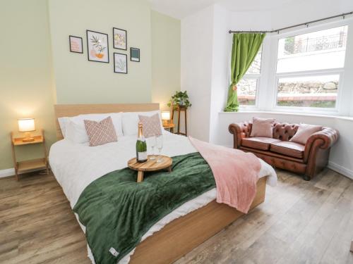 a bedroom with a bed with a bottle of wine on it at Ty Arth in Llandudno
