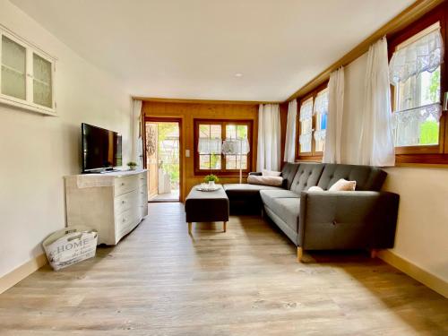 a living room with a couch and a television at Rosenhüsli in Gerzensee