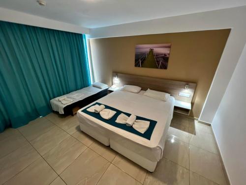 a hotel room with two beds with towels on them at Sunny Blue Hotel in Ayia Napa
