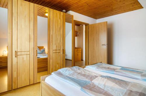 a bedroom with two beds and wooden cabinets at Ferienwohnung am Birnbaum in Überlingen