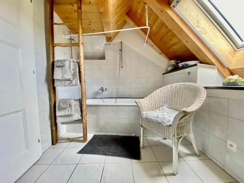 a bathroom with a chair and a bath tub at Rosenhüsli in Gerzensee