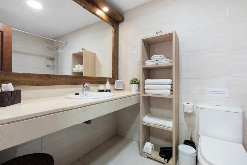 y baño con lavabo, espejo y aseo. en Luxury Candesol ii, en Puerto de Santiago