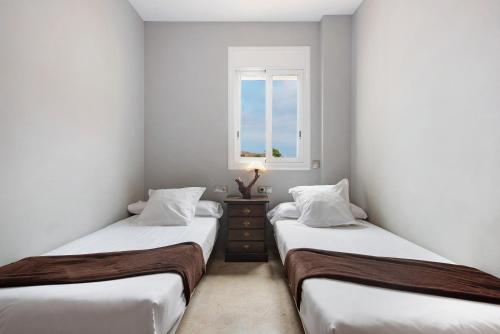 2 camas individuales en una habitación con ventana en Luxury Candesol ii, en Puerto de Santiago