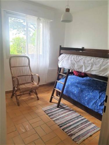 une chambre avec un lit superposé et une chaise dans l'établissement Appartement vue mer, 2 chambres, à Quiberon