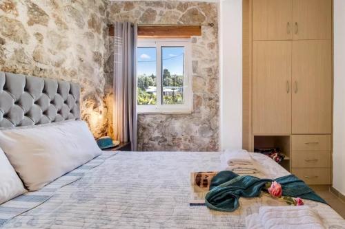 - une chambre avec un grand lit et un mur en pierre dans l'établissement Gkountis Apartments, à Tsoukaladhes